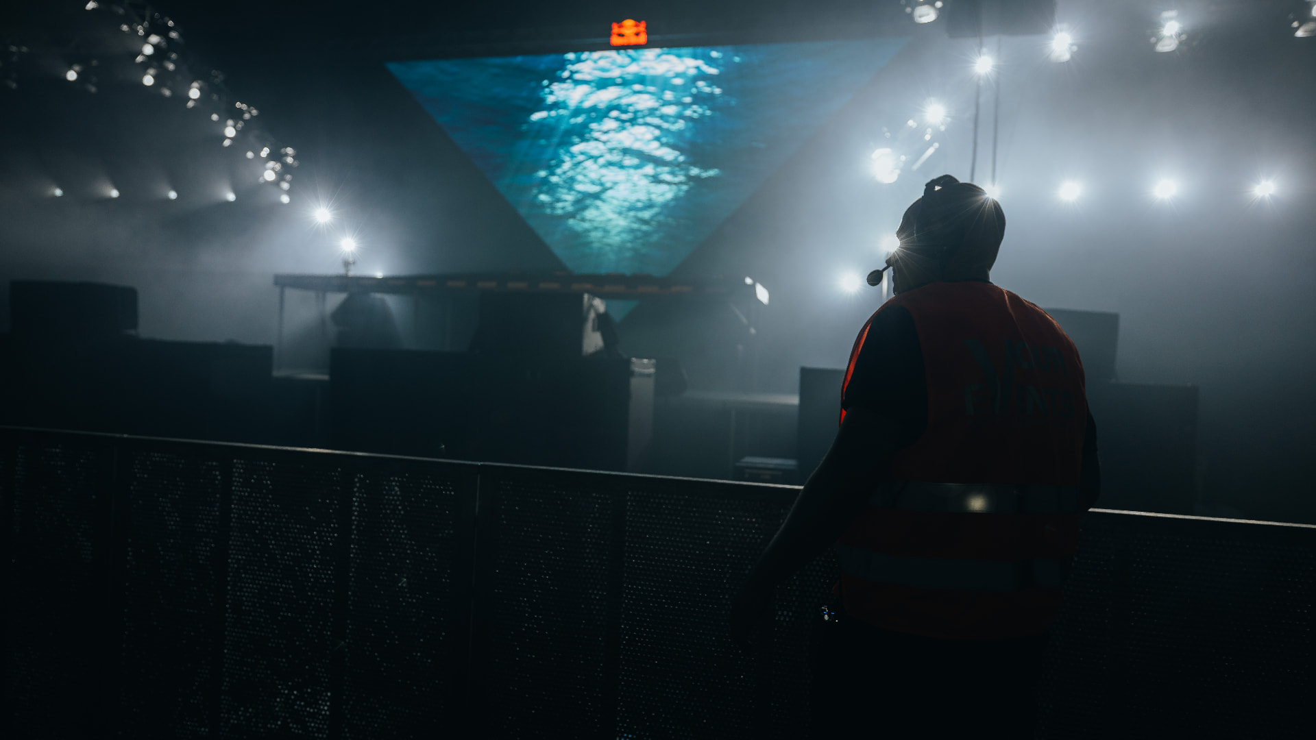 Security steward watching the stage from the barricade in the fog — Bassment Festival, photographed by Paul Rumplmaier