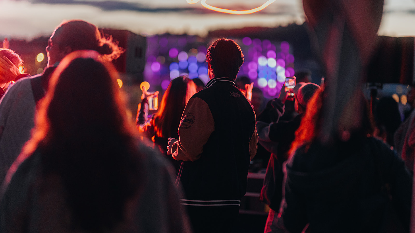 Guests watching the sunset set in front of purple lights — Bisou.at, photographed by Paul Rumplmaier