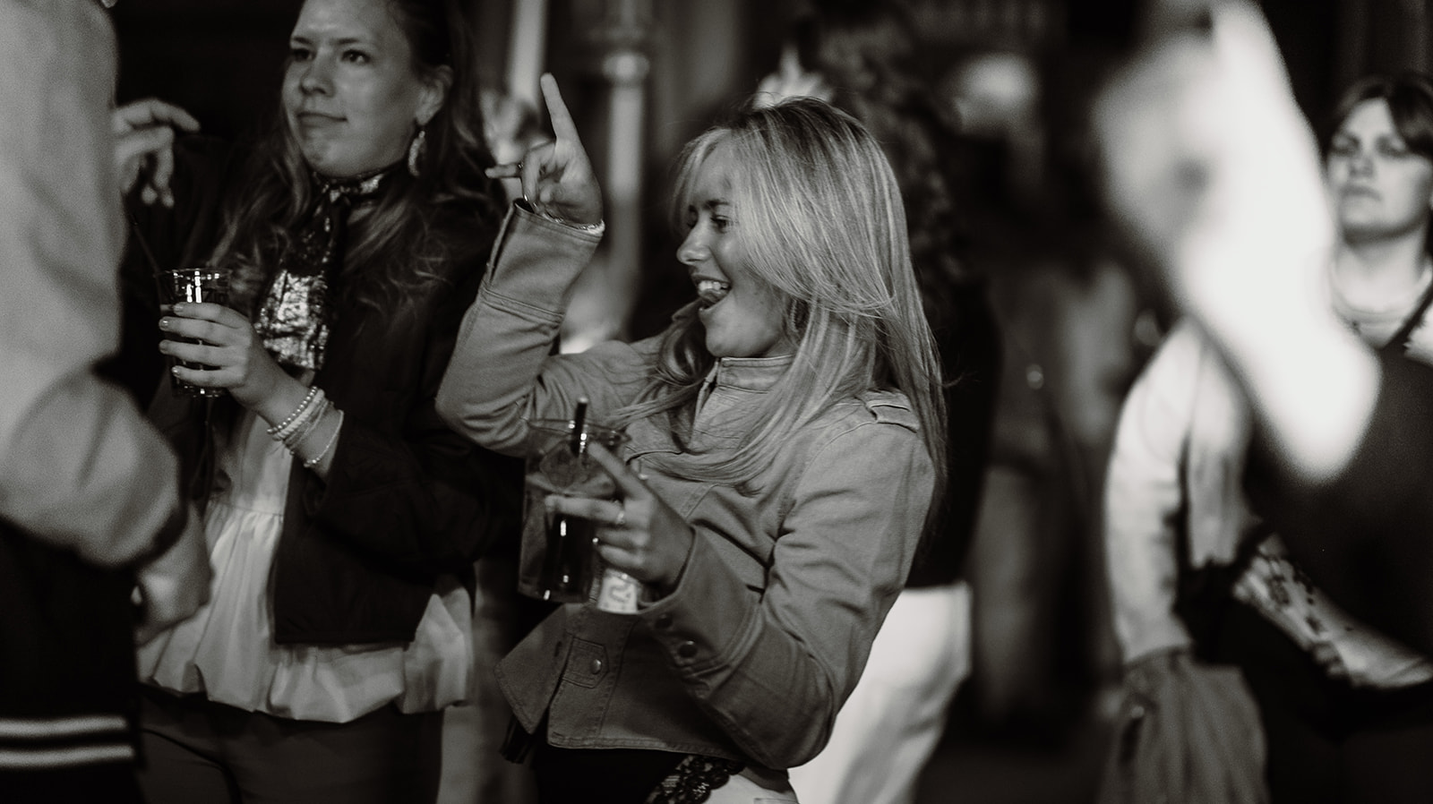 Black and white frame of guests dancing with drinks — Bisou.at, photographed by Paul Rumplmaier