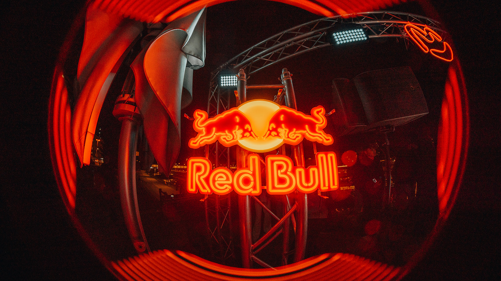 Glowing red Red Bull neon sign above the rig at night — Bisou.at, photographed by Paul Rumplmaier