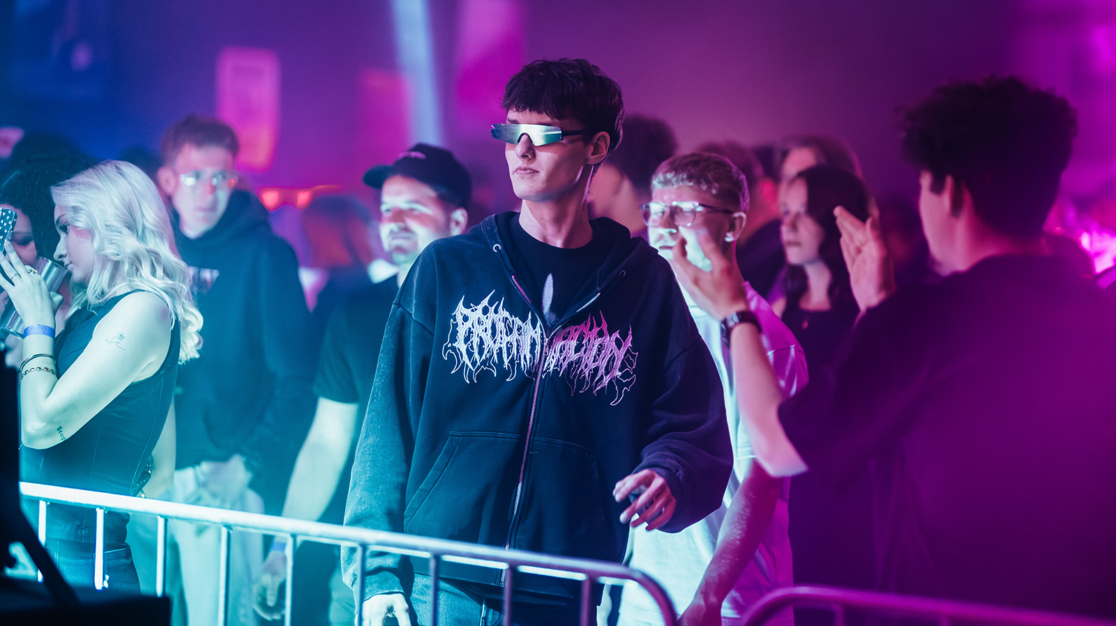 Raver in visor sunglasses at the barricade in pink and blue light — Best of, photographed by Paul Rumplmaier