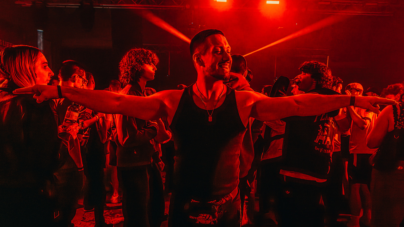 Crowd with arms outstretched in deep red club light — Best of, photographed by Paul Rumplmaier