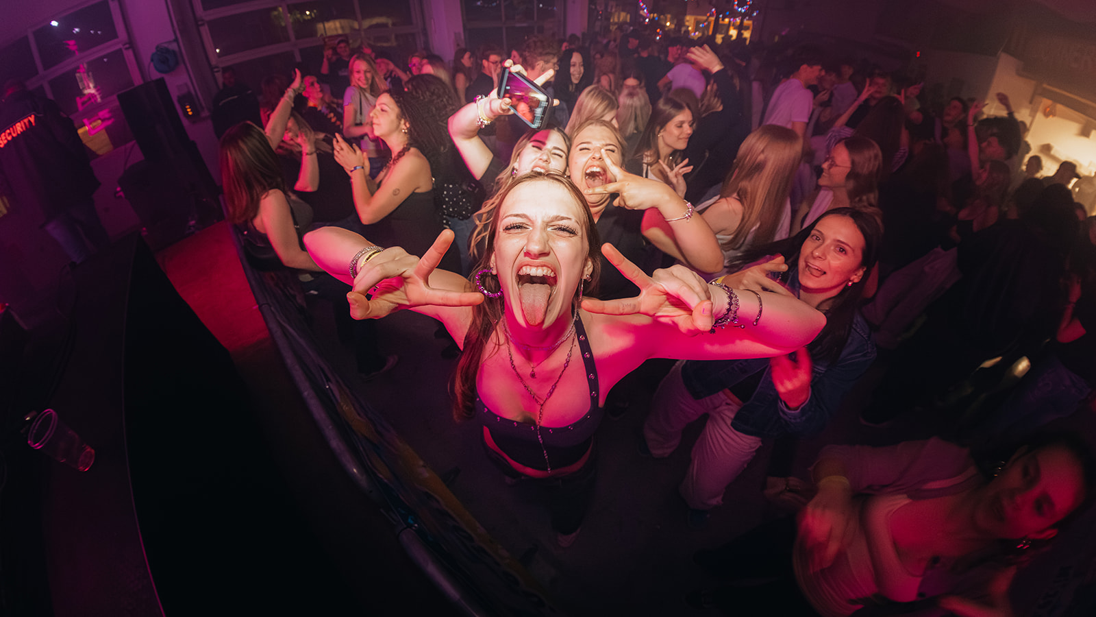 Fisheye frame of a laughing crowd in pink light — Best of, photographed by Paul Rumplmaier
