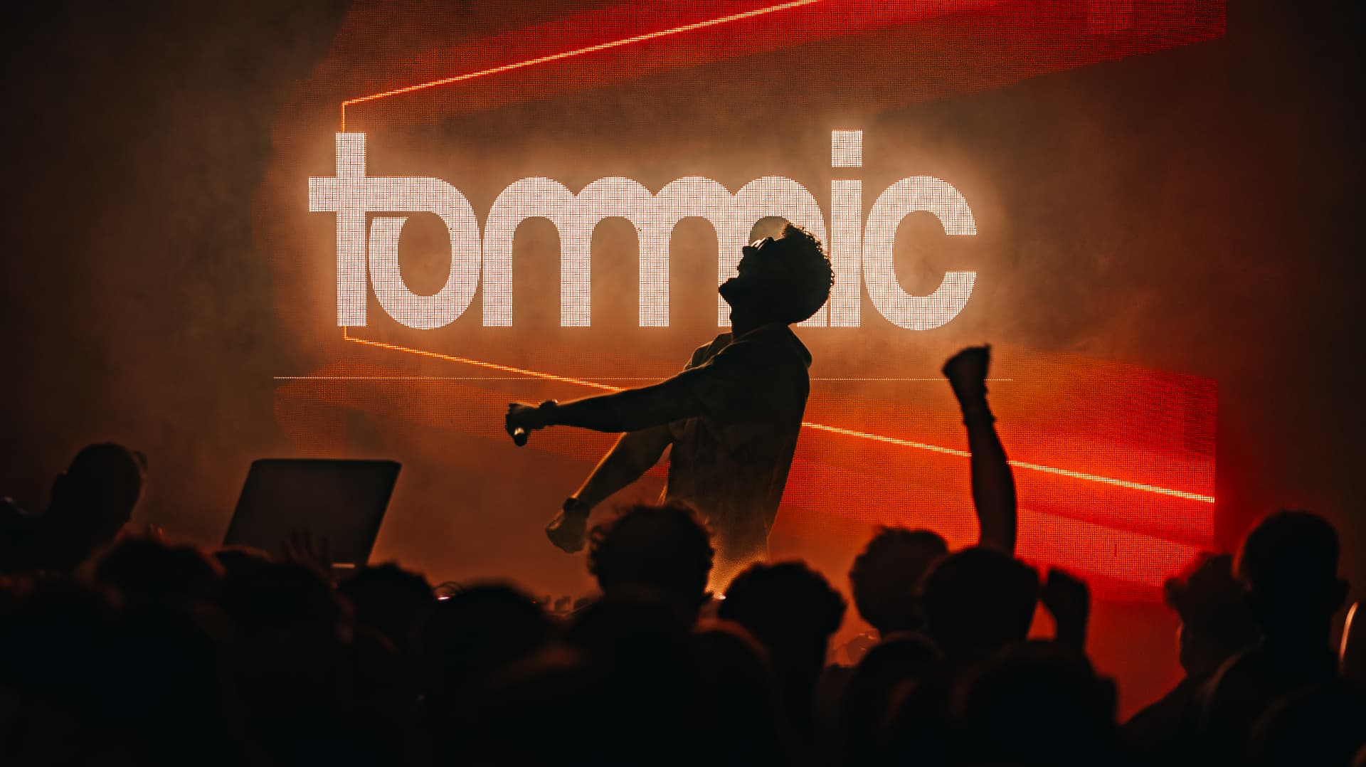 Silhouetted artist leaping in front of a glowing tommic LED wall — Best of, photographed by Paul Rumplmaier