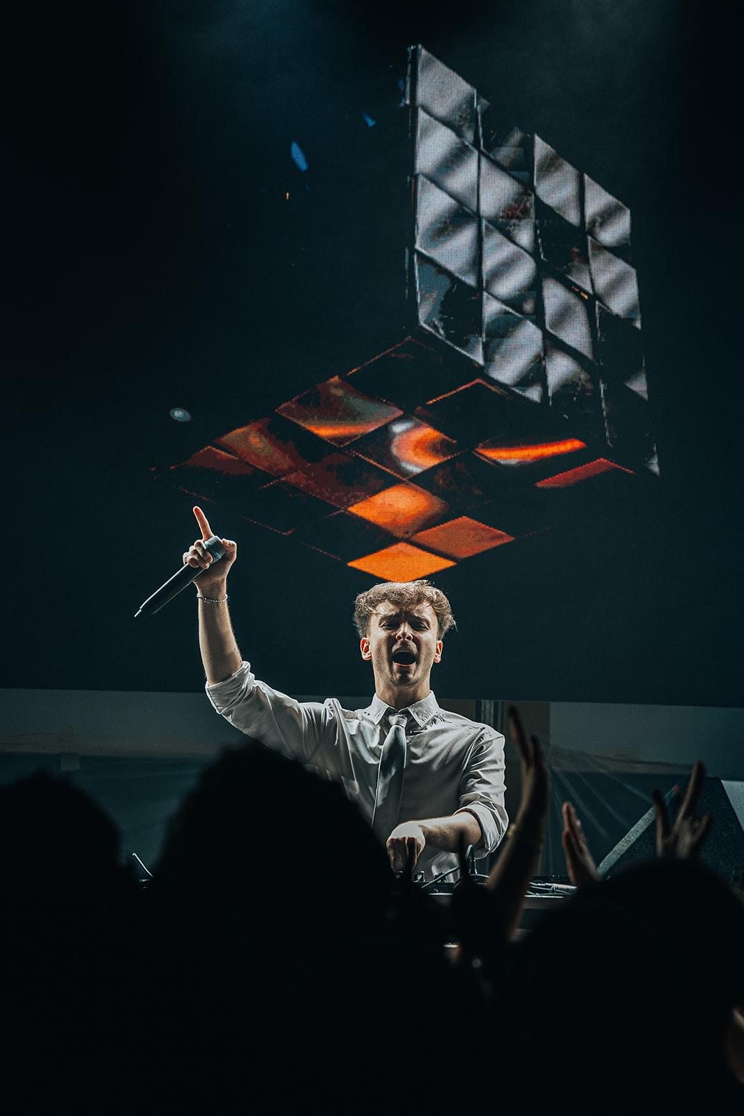 DJ pointing to the crowd beneath a floating LED cube — Best of, photographed by Paul Rumplmaier