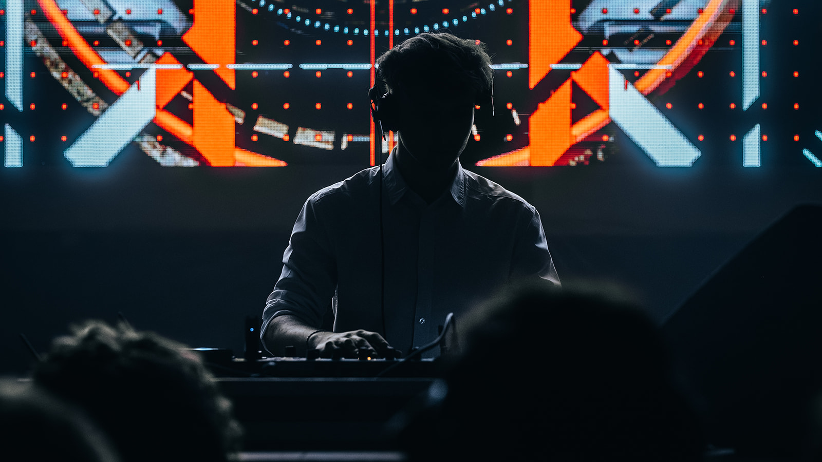 DJ silhouetted against an orange and blue LED backdrop — Best of, photographed by Paul Rumplmaier