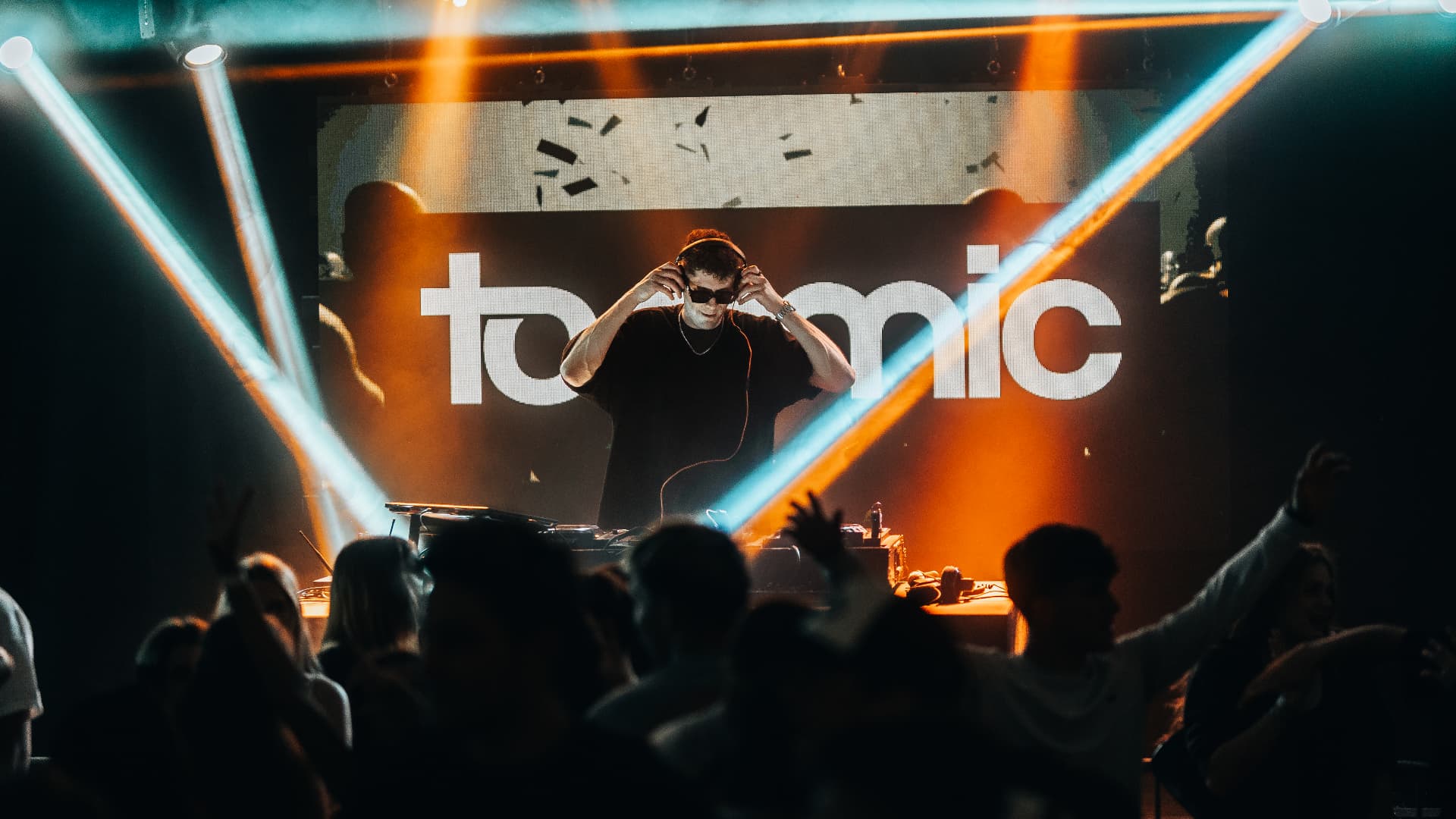 DJ behind the decks in front of the tommic LED wall with blue laser beams — Best of, photographed by Paul Rumplmaier