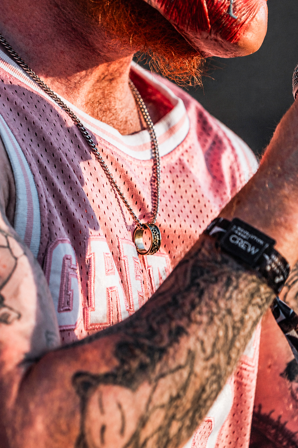 Close-up of an artist's jersey, chain and tattooed arm — Shutdown Festival, photographed by Paul Rumplmaier