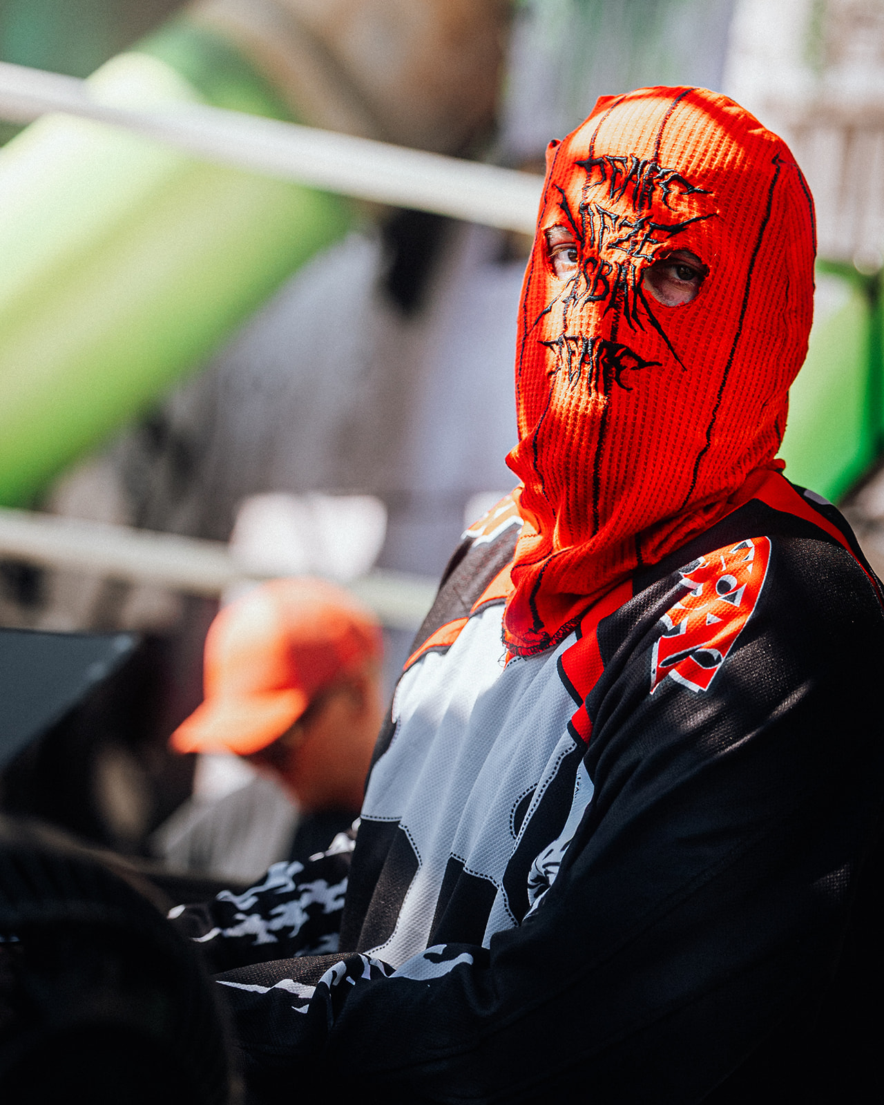 Performer in an orange balaclava behind the decks — Shutdown Festival, photographed by Paul Rumplmaier