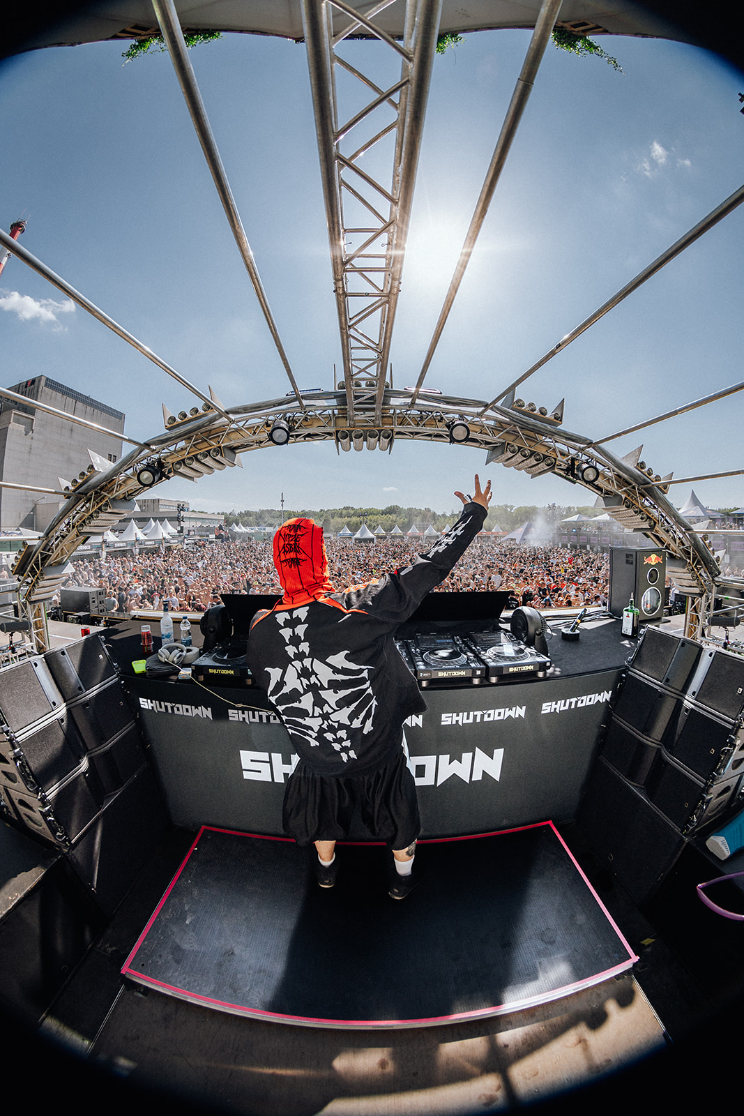 Artist behind the Shutdown decks facing a packed daytime crowd — Shutdown Festival, photographed by Paul Rumplmaier